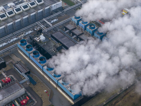 Aerial view of a large ai data center complex. Rows of cooling towers releasing steam, symbolizing technology, energy, and infrastructure
