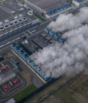 Aerial view of eemshaven data center emitting steam from cooling towers, Netherlands