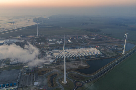 Aerial view of large data center facility in eemshaven, netherlands, operating with wind turbines for sustainable energy and cloud computing