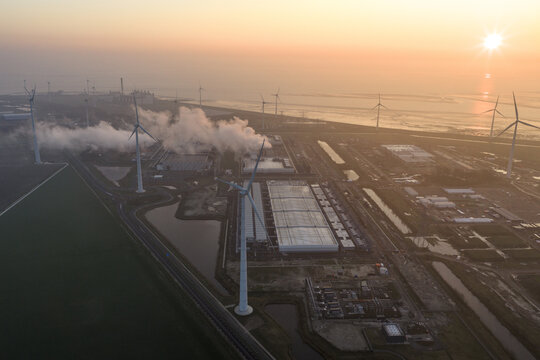 Aerial view of aerial view of a large hyperscale data center operating with surrounding wind turbines, showing cloud computing and ai infrastructure