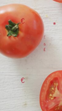 Vertical video: Cut starting red symbols drifting onto tomato pair halved on board for food pricing