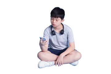 Boy immersed in smartphone: A young boy, absorbed in his phone, sits cross-legged, the modern technology has captured his full attention © NETI studio