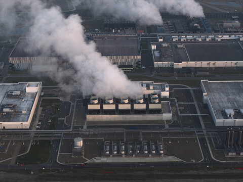 Aerial view of artificial intelligence data center emitting steam from cooling system