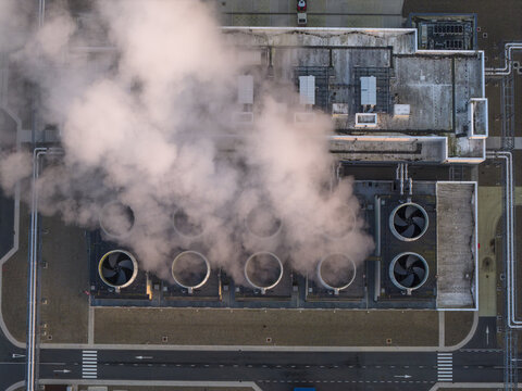 Aerial view of data center cooling towers and industrial infrastructure releasing steam, representing technology and energy