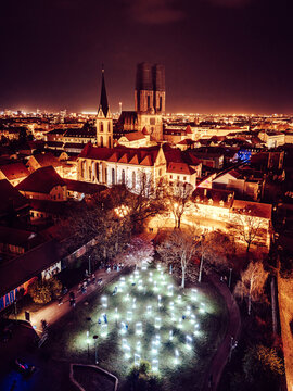 Aerial view of the Zagreb Cathedral towering amidst the city's glowing tapestry, with illuminated installations casting a soft glow on the park below, Zagreb, Croatia.