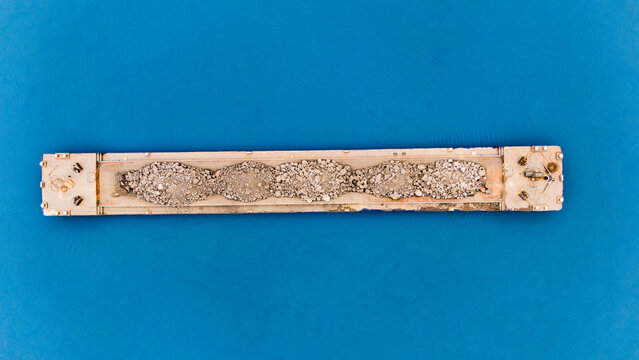 Aerial view of a rectangular object filled with small stones, set against a striking blue backdrop, Sremska Mitrovica, Vojvodina, Serbia.