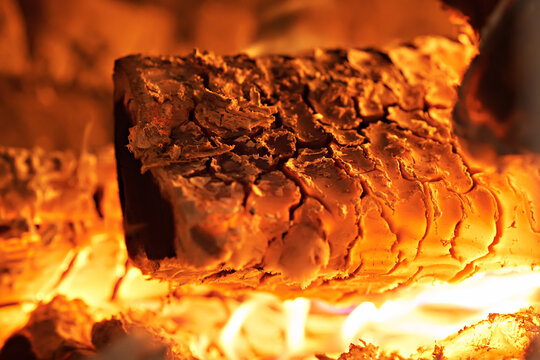 Homemade warm orange campfire with pieces of firewood. Burning firewood in the stove, coal, hot coals,