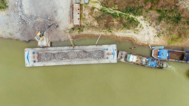 Aerial view of barges moored along the bank, their weathered exteriors contrasting with the muddy waters, Sremska Mitrovica, Vojvodina, Serbia.