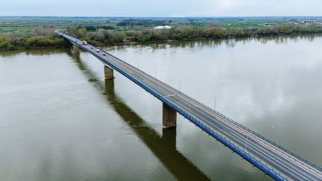 Aerial view of a bridge cutting through the landscape, its slender form reflecting in the tranquil waters below, Sremska Mitrovica, Vojvodina, Serbia.