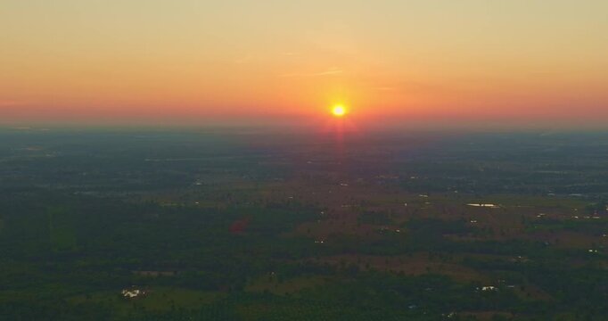 Aerial view of Smoke from burning fields spreads across the rural sky, slowly erasing the colors of sunset and turning a peaceful evening into a sign of environmental harm.