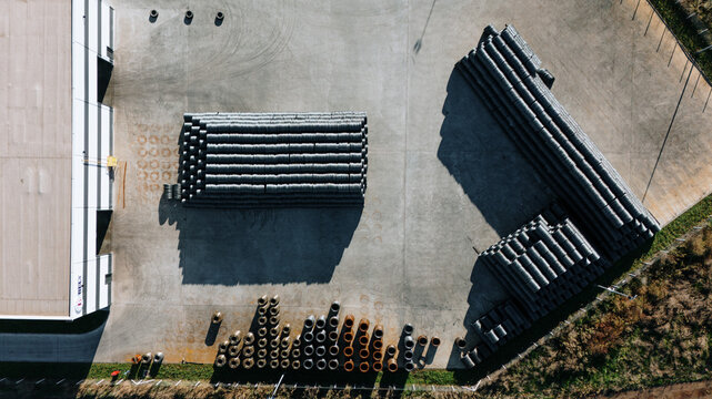 Aerial view of neatly stacked pipes casting stark shadows, creating a geometric dance of light and form, Sremska Mitrovica, Vojvodina, Serbia.
