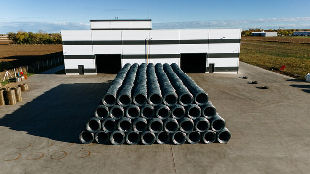 Aerial view of stacked coils of metal wire creating a strong contrast against the modern building, Sremska Mitrovica, Vojvodina, Serbia.