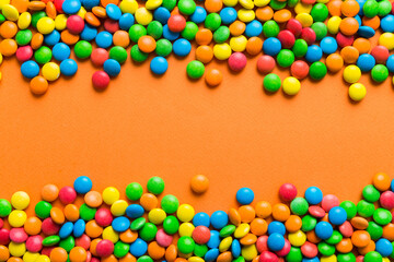 Obraz premium Mixed collection of colorful candy, on colored background. Flat lay, top view. frame of colorful chocolate coated candy