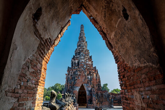 Chedis seen through a stone archway at the ruins of Wat Chaiwatthanaram, an ancient temple in Ayutthaya, the historical capital of Siam. A UNESCO World Heritage site. 