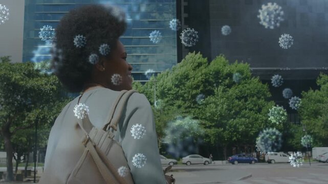 Animation of corona virus floating against african lady waiving hand on city street