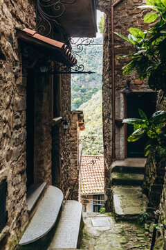 View of a narrow stone alley with steps and traditional architecture in the medieval village of Apricale, Liguria, Italy
