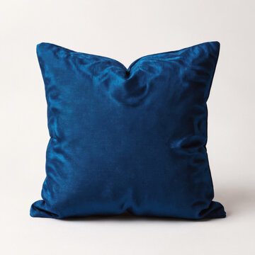 A blue velvet pillow on a plain light grey background, nigerian adire pattern cushion product photography