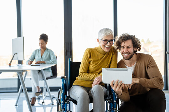 The image includes a person using a wheelchair, depicting inclusivity and teamwork in modern office