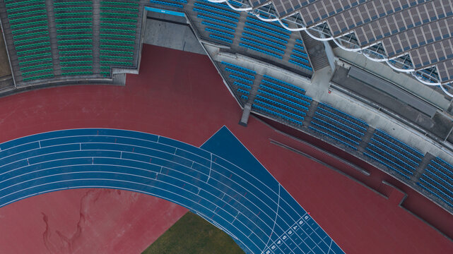 Aerial view of the Kaohsiung National Stadium featuring the blue running track and empty spectator seating in Fuxingli, Kaohsiung City, Taiwan.