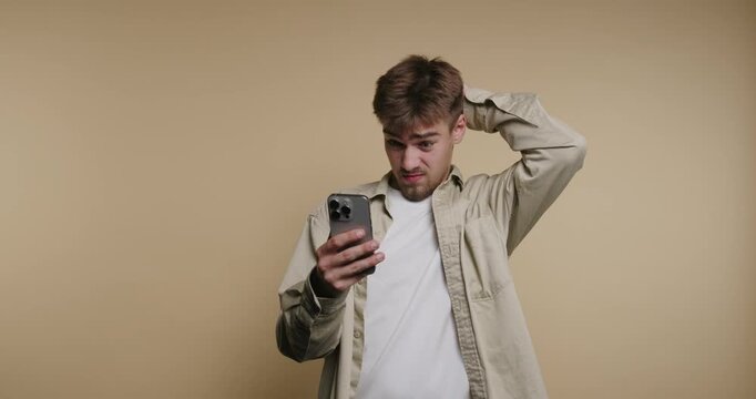 Confusion and discovery unfold as a man explores a mobile screen in a cozy studio setting