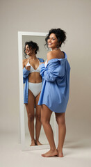 Naklejka premium Smiling Woman in Blue Shirt and White Underwear Mirror Reflection