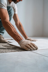 Fliesenleger verlegt Bodenplatten in Küche