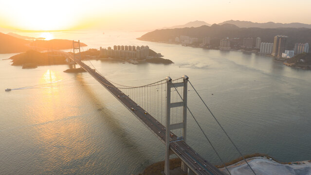 Aerial view of the Tsing Ma Bridge at sunset with the city skyline and mountains in the background Hong Kong, China.