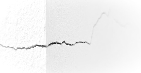 Obraz premium Close-up of a deep crack in a white concrete wall corner, representing structural damage, building failure, and repair needs.