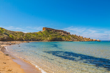 Obraz premium Clay Cliffs in Malta on a sunny day, featuring striking reddish rock formations, rugged coastline, and the deep blue Mediterranean Sea creating a dramatic and scenic landscape.