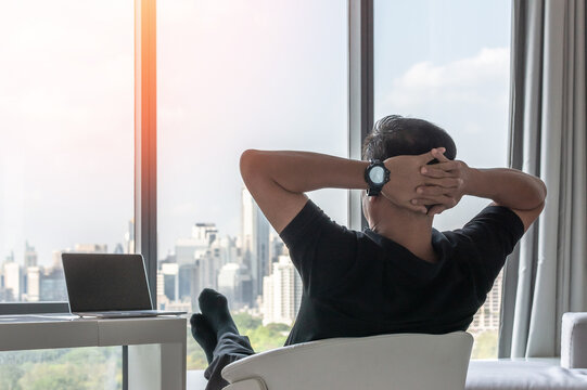 Work-life balance and living life style concept of businessman relaxing, take it easy in hotel or office room resting with thoughtful mind thinking of lifestyle quality looking forward to city