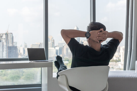 Work-life balance and living life style concept of businessman relaxing, take it easy in hotel or office room resting with thoughtful mind thinking of lifestyle quality looking forward to city