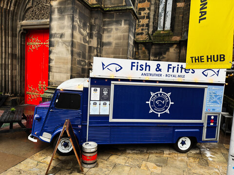 Blue Fish Frites food truck on the Royal Mile in Edinburgh, Scotland, UK parked outside historic stone church