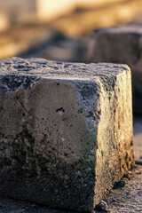 Fototapeta premium A single concrete block sitting beside a road, ideal for use in urban or infrastructure-themed designs
