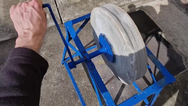 pedal-powered or hand-cranked grindstone sharpening edged tools knives, axes, and scythes.Grinding Wheel large, thick disc is likely made of natural sandstone composite abrasive material wheels are de