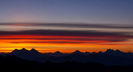 Fototapeta premium Vibrant Sunset Over Mountain Silhouettes with Dramatic Color Gradient Sky