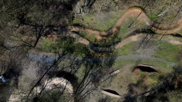 pump track or dirt jump park designed for mountain bikes MTB or BMX. trails rollers humps and berms banked corners goal is navigate track without pedaling, pumping motion pushing down into the dips 