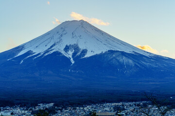 Fototapeta premium 富士吉田市から望む富士山と街並み 冠雪した美しい山岳風景 