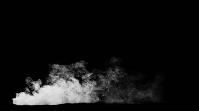 White plume of smoke flow from the ground and staying down with strong side wind on a black background