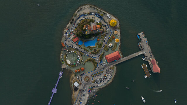 Aerial view of Koh Loy island featuring the hilltop temple, turtle pond, and coastal infrastructure in Si Racha, Chonburi, Thailand.