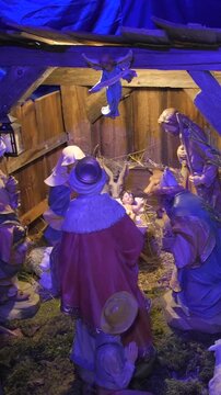nativity scene with baby jesus and three kings inside church, wide vertical pan