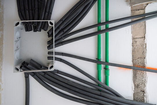 Electrical installation with conduit pipes and junction box inside wall during home renovation