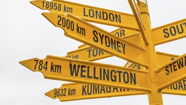 Yellow signs, signpost with different destinations, cities and distances, Bluff, South Island, New Zealand