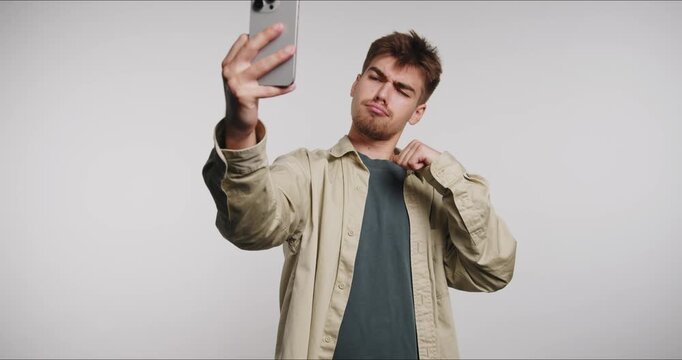Capturing joyful moments with playful expressions while taking selfies at a bright studio