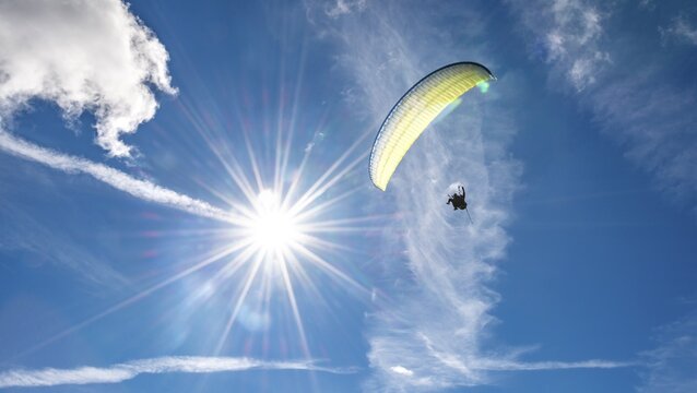 Paraglider flying in the sky, sunbeams, Grindelwald, Bern, Switzerland