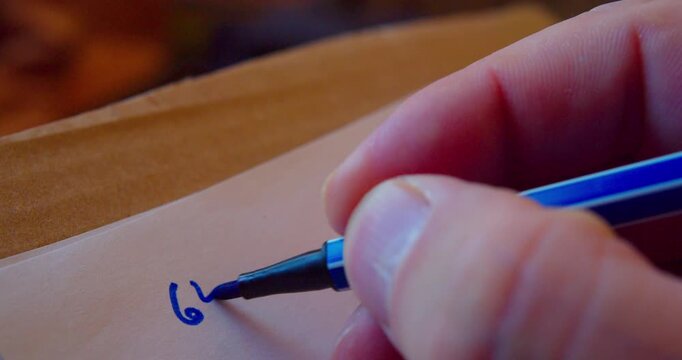 A detailed close-up of a marker writing numbers on a piece of paper.