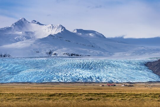 Icelandic farmstead with glacier tongue and snow-covered mountains, H&ouml;fn, Iceland