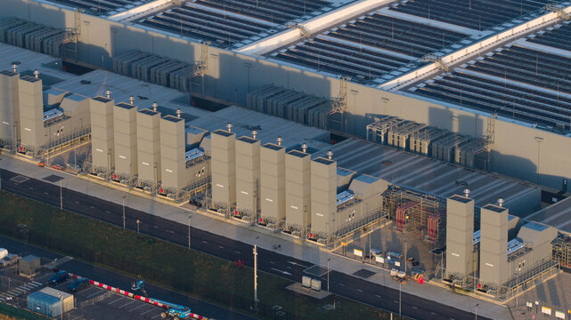 Aerial view of Datacenter Winschoten featuring industrial cooling towers, large roof structures, and solar panel arrays in Winschoten, Groningen, Netherlands.