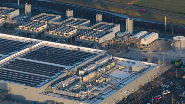 Aerial view of the Google Data Center Winschoten featuring cooling units, rooftop solar panels, and a parking lot in Winschoten, Netherlands.