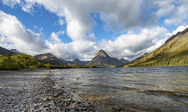 Shores of Two Medicine Lake, in the background mountain peaks Sinopah Mountain, Never Laughs Mountain and Appistoki Peak, Glacier National Park, Montana, USA