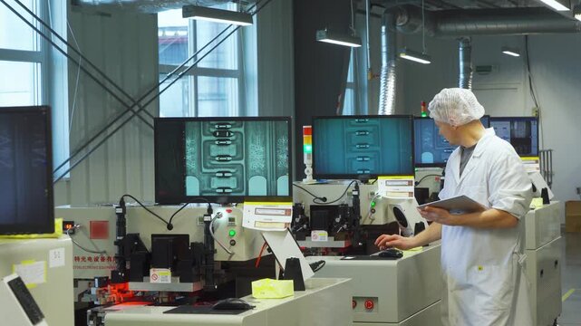White supervisor conducting final quality inspection on assembled circuits, comparing monitor readings, validating compliance and traceability, preparing parts for shipment from manufacturing line